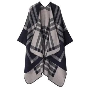 Detailed view of the thick knit plaid cape showing the soft fabric texture and neat stitching.