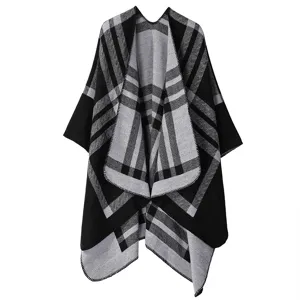 Detailed view of the black and grey plaid knitted poncho showing the soft texture and pattern.