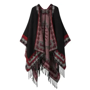 Detail view of bohemian ethnic style geometric pattern knitted poncho shawl with fringe hem.