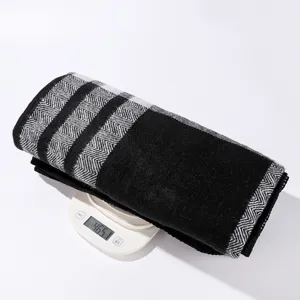 Detailed view of the thickened black and white plaid knit shawl displayed on a scale.