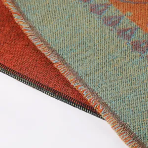 Close-up view of ethnic style woven blanket shawl fabric texture with colorful fringe detail.