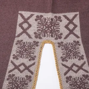 Close-up detail of winter women knit poncho shawl, showing soft fabric texture and pattern.