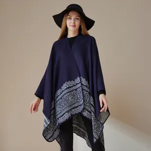 Detailed view of the women's navy blue knitted poncho showing the intricate pattern hem.