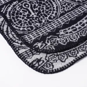 Detailed close-up of the thick knit shawl fabric showing vintage black and white pattern and neat edges.