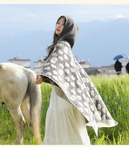 Detailed view of the thick hooded cape shawl with cozy fabric, perfect for outdoor travel.