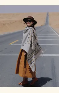 Sciarpa in finto cashmere stile etnico con motivo geometrico e frange in ambientazione deserto.