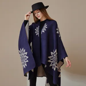 Detailansicht eines eleganten dunkelblauen Strickponchos mit beigeem Blumenmuster und Hut.