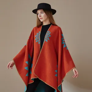 Nahaufnahme des ethnischen Strick-Ponchos mit lebendigen blauen geometrischen Mustern.