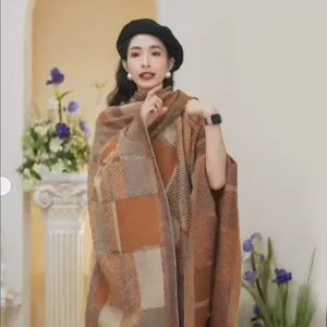 Detail view of women's autumn winter brown plaid knit shawl cape outerwear cozy fashion
