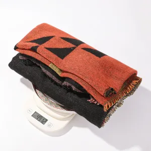 Detailed view of the geometric patterned tassel scarf showing texture and exact weight.