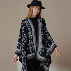 Detailed view showing the textured geometric patterned black winter knit shawl cape.