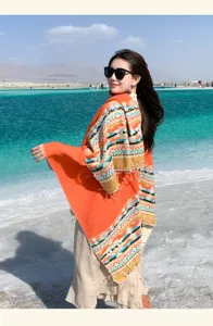 Dettaglio mantello invernale caldo con motivo etnico colorblock, elegante scialle.