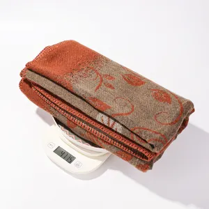 Detail view of the warm knitted shawl fabric texture and weight display on scale.