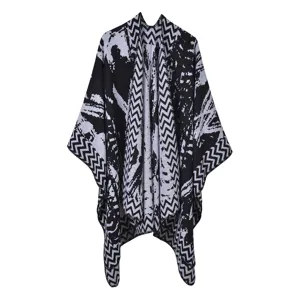 Detailansicht des schwarz-weißen abstrakten geometrischen Strickumhangs, weich und warm für den Winter.