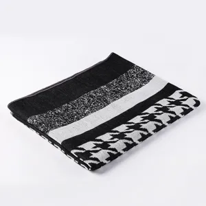 Detailaufnahme der schwarz-weißen Hahnentritt Strickschal Textur mit weicher und warmer Haptik.