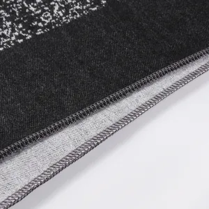 Nahaufnahme des Strick-Kaschmir-Schalrandes mit feiner Overlock-Naht-Strukturdetails.