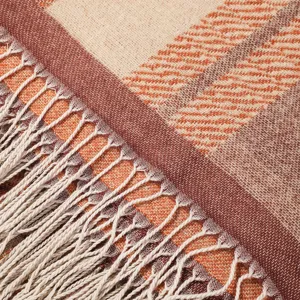 Autumn ethnic style plaid fringe shawl detail close-up, thick knit women winter scarf texture.