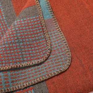 Detailed view of the cozy plaid cashmere-feel shawl blanket, showing soft fabric texture.