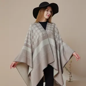 Nahaufnahme des stilvollen Hahnentritt gestreiften Strick-Ponchos, elegante Winterkleidung.