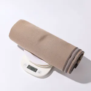Einfarbiger gemütlicher warmer Schal eingerollt auf Waage zur Detailansicht des Materials.