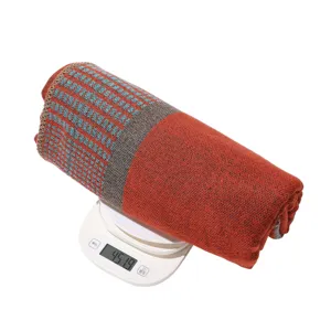 Detailed view of rolled autumn winter plaid imitation cashmere shawl scarf showing weight.