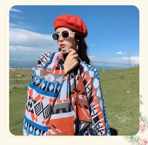Detailed view of women boho geometric print tassel cape scarf, outdoor travel fashion.