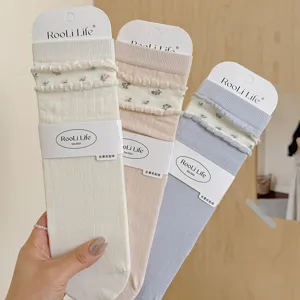 Detailed shot of women Korean style stack socks with floral ruffle cuff and soft ribbed fabric.