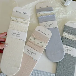 Close-up detail of women's floral ruffle crew socks, showcasing delicate knitted texture.