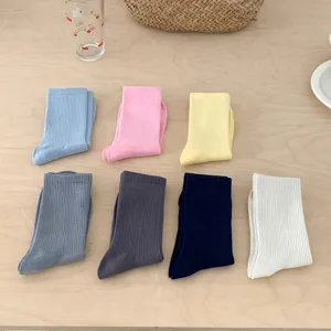Detailed shot of solid color ribbed mid-tube socks in various candy shades, soft and cozy wear.