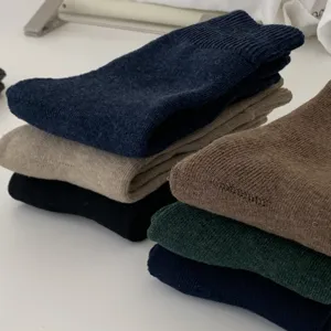 Gros plan détaillé de chaussettes bouclettes d'hiver épaisses empilées en plus couleurs.