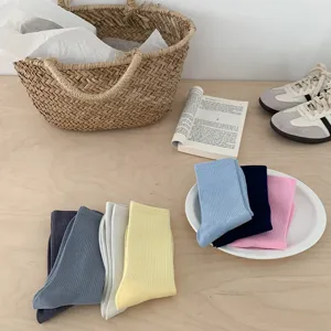 Detailed close-up of colorful ribbed mid-calf candy socks styled on a wooden tabletop.