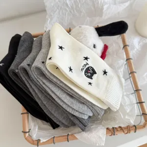 Close up detail view of stacked women mid tube socks with cute cat and star embroidery.