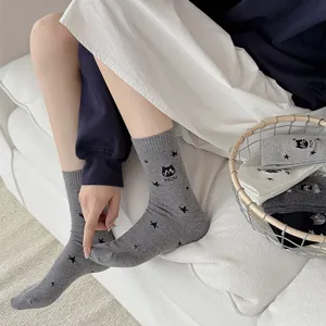 Close-up detail of gray mid-tube women socks featuring cute cat and star embroidery patterns.