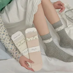 Close-up detail showing the delicate floral ruffle design and soft stacked texture of women's socks.