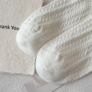Detailed view of white knit socks showcasing fine texture and breathable summer pattern.