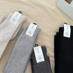 Detail view of the thick over-the-knee fleece socks in various solid winter colors.