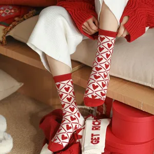 Gros plan détail de chaussettes en laine chaudes d'hiver à motif de cœur rouge et blanc