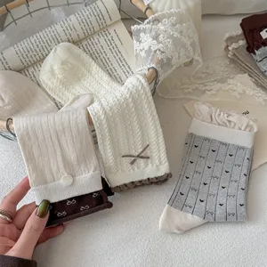Detailed view of women's sweet mid-tube socks featuring cable knit, cute bows and heart embroidery.