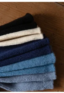 Detailansicht kuscheliger, dicker Strick-Wintersocken in bunten Farben gestapelt.