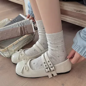 Detailed close-up view of women floral mid tube socks paired with stylish white Mary Jane shoes.