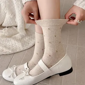 Close-up detail of vintage floral cotton mid-calf socks paired with white flats, soft knit.