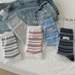 Vue détaillée de chaussettes mi-hautes rayées style rétro avec étiquette en tissu, look polyvalent.