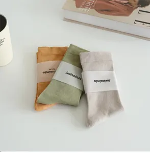 Detailed shot of Morandi colored women crew socks, soft cotton fabric, elegant solid design.
