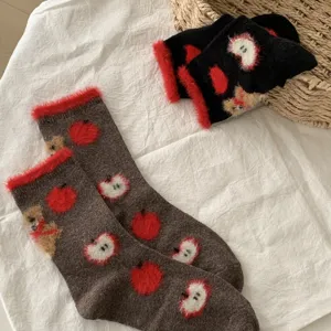 Fluffy winter socks detail featuring cute teddy bear and red apple knit patterns for cozy wear.