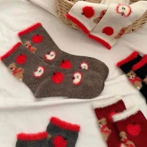 Plush fuzzy socks detail view featuring cute red apple and brown bear knit patterns, cozy winter wear.