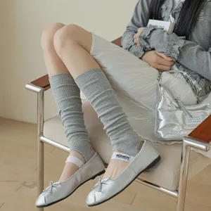 Detail view of grey knitted stirrup leg warmers, showing fine texture and stylish fit.