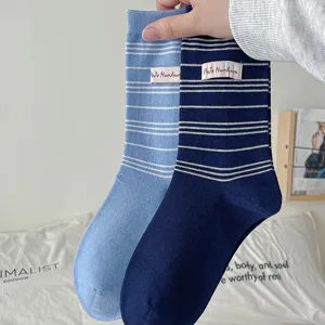 Vue détaillée de chaussettes mi-hautes à rayures avec étiquette en tissu style rétro.