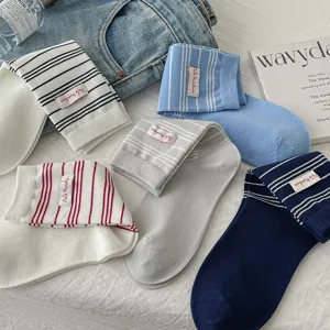 Vue détaillée de chaussettes mi-hautes rayées rétro américaines avec petite étiquette en tissu.