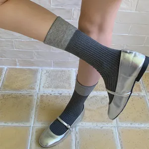 Women contrast color ribbed crew socks paired with shiny silver mary jane shoes detail view