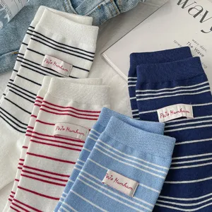 Gros plan détaillé de chaussettes mi-mollet à rayures avec étiquette, style collège.